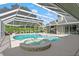Screened-in pool with a built-in spa and outdoor kitchen area, perfect for relaxation and entertaining guests at 17311 Carriage Way, Odessa, FL 33556