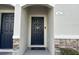 Welcoming front entrance with a dark blue door, modern hardware, and stone accents at 1941 Greenwood Valley Dr, Plant City, FL 33563