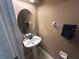 Well-lit half-bath featuring a pedestal sink, modern fixtures, and neutral tones at 1941 Greenwood Valley Dr, Plant City, FL 33563