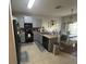 Bright kitchen featuring grey cabinets, modern appliances, and a breakfast bar at 1941 Greenwood Valley Dr, Plant City, FL 33563