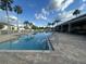 Community pool surrounded by palm trees and a covered patio area at 1941 Greenwood Valley Dr, Plant City, FL 33563