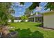 Large backyard with lush green lawn and a fire pit, framed by mature trees and a white fence at 2535 Regal River Rd, Valrico, FL 33596
