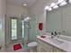 Bathroom with a glass-enclosed shower, modern vanity, and an exterior door for added convenience at 2535 Regal River Rd, Valrico, FL 33596