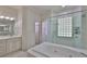 Bright bathroom features a large soaking tub and walk-in tiled shower with glass block window at 2535 Regal River Rd, Valrico, FL 33596