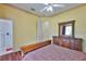 Cozy bedroom with a floral-patterned bedspread, wood furniture, and natural light from the doorway at 2535 Regal River Rd, Valrico, FL 33596