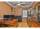 Well-lit office features hardwood floors, a leather loveseat and custom wood cabinets at 2535 Regal River Rd, Valrico, FL 33596