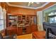 Office features hardwood floors, custom wood cabinets and shelves and comfortable seating at 2535 Regal River Rd, Valrico, FL 33596
