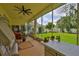 Screened patio featuring tile flooring, ceiling fan, and views of the large backyard at 2535 Regal River Rd, Valrico, FL 33596