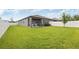 Expansive backyard with lush green grass, a white fence, and a covered patio, ideal for outdoor enjoyment at 288 Villa Corte Dr, Lutz, FL 33549