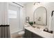 Modern bathroom features a tiled shower/tub combination, vanity with modern fixtures, decor, and an oval mirror at 288 Villa Corte Dr, Lutz, FL 33549