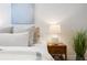 Cozy bedroom corner featuring a decorative wall hanging, bedside table with lamp, and leafy plant at 288 Villa Corte Dr, Lutz, FL 33549