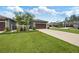 Charming home with a well-manicured lawn, gray exterior, and a large driveway leading to a two-car garage at 288 Villa Corte Dr, Lutz, FL 33549