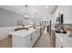 Open-concept kitchen features white cabinets, a large island, modern appliances, and overlooks the home's living spaces at 288 Villa Corte Dr, Lutz, FL 33549