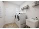 Clean laundry room with a modern washer and dryer, utility sink, storage shelf, and a door to outside at 288 Villa Corte Dr, Lutz, FL 33549