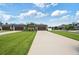 Street view showcasing newly built homes, manicured lawns, and freshly paved driveways at 288 Villa Corte Dr, Lutz, FL 33549