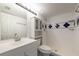 Bright bathroom featuring white tiled shower and vanity, with blue accent tile at 3114 Lake Pine Way # H2, Tarpon Springs, FL 34688