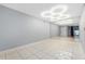 Bright bedroom featuring tile floor, mirrored wall, and modern light fixture at 3114 Lake Pine Way # H2, Tarpon Springs, FL 34688
