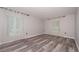 Bright and airy bedroom with wood-look flooring and sheer curtains, showcasing natural light at 3114 Lake Pine Way # H2, Tarpon Springs, FL 34688