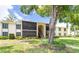 Charming two-story condo building with lush landscaping, walkway, and screened-in lanais at 3114 Lake Pine Way # H2, Tarpon Springs, FL 34688