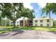 Condo exterior featuring lush landscaping, mature trees, and assigned parking at 3114 Lake Pine Way # H2, Tarpon Springs, FL 34688