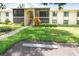 Inviting condo exterior with well-maintained lawn, landscaping, and assigned parking at 3114 Lake Pine Way # H2, Tarpon Springs, FL 34688