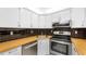 Updated kitchen boasts stainless steel appliances, wood countertop, and modern backsplash at 3114 Lake Pine Way # H2, Tarpon Springs, FL 34688