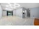Bright living room features stylish lighting, a mirrored wall, and white tile flooring at 3114 Lake Pine Way # H2, Tarpon Springs, FL 34688