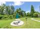 Shaded picnic area on a sunny day with a table, grill, and lush green surroundings at 3114 Lake Pine Way # H2, Tarpon Springs, FL 34688