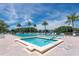 Resort-style pool area with sparkling blue water, lounge chairs, palm trees, and sunny sky at 3114 Lake Pine Way # H2, Tarpon Springs, FL 34688