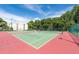 Outdoor tennis courts with green and red surfacing, surrounded by trees and greenery at 3114 Lake Pine Way # H2, Tarpon Springs, FL 34688