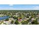Overhead view shows a neighborhood with mature trees and a lake in the background on a bright, sunny day at 3133 Payne St, New Port Richey, FL 34655