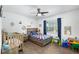 bedroom featuring wood floors, a ceiling fan, a crib, and colorful decor at 3133 Payne St, New Port Richey, FL 34655