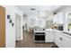 Open kitchen with stainless steel appliances, leading to the dining area with contemporary pendant lighting at 3133 Payne St, New Port Richey, FL 34655