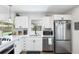 Bright kitchen featuring white cabinetry, stainless steel appliances, and a window overlooking the backyard pool at 3133 Payne St, New Port Richey, FL 34655