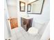 Bright bathroom featuring a white toilet, dark vanity and white-tiled flooring and large mirror at 3304 Alamar St, Lutz, FL 33558