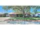 Charming home featuring a mature tree, metal roof, and easy access driveway at 3304 Alamar St, Lutz, FL 33558