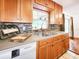 The kitchen showcases custom cabinets, a tiled backsplash, stainless steel sink, and natural light from the window at 3304 Alamar St, Lutz, FL 33558
