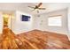 Bright living room with hardwood floors, a ceiling fan, and a view of the front door and hallway at 3304 Alamar St, Lutz, FL 33558