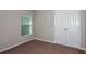 Cozy bedroom with plush carpeting and a window offering natural light, adjacent to closet for storage at 36958 Sagemoor Dr, Zephyrhills, FL 33541