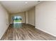 Bright living room with wood-look floors and sliding glass doors leading to the backyard at 36958 Sagemoor Dr, Zephyrhills, FL 33541