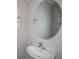 Bathroom features a pedestal sink and an oval mirror with decorative accents at 36964 Sagemoor Dr, Zephyrhills, FL 33541