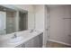 Bathroom featuring double vanity, grey cabinets, large mirror, and shower/tub combo at 36964 Sagemoor Dr, Zephyrhills, FL 33541