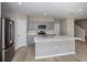 Modern kitchen features stainless appliances, gray cabinets, a large island, and wood-look flooring at 36964 Sagemoor Dr, Zephyrhills, FL 33541