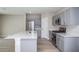 Modern kitchen features gray cabinets, stainless steel appliances, and a spacious white countertop island at 36964 Sagemoor Dr, Zephyrhills, FL 33541