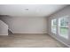 Spacious living room with wood-look floors and staircase, bathed in natural light from two windows at 36964 Sagemoor Dr, Zephyrhills, FL 33541