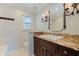 Inviting bathroom showcasing vanity with granite countertop, unique mirror, and decorative sconces at 417 41St Ave, St Pete Beach, FL 33706