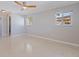 Empty bedroom with light gray walls, a ceiling fan, windows and polished floors at 417 41St Ave, St Pete Beach, FL 33706