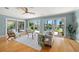 Bright living room with hardwood floors, ceiling fan, and large sliding glass doors overlooking the backyard at 417 41St Ave, St Pete Beach, FL 33706