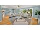 Bright living room featuring hardwood floors, comfortable seating, and views of lush greenery at 417 41St Ave, St Pete Beach, FL 33706
