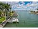A waterfront property featuring a private dock, lush palm trees, and stunning views of the tranquil bay at 417 41St Ave, St Pete Beach, FL 33706